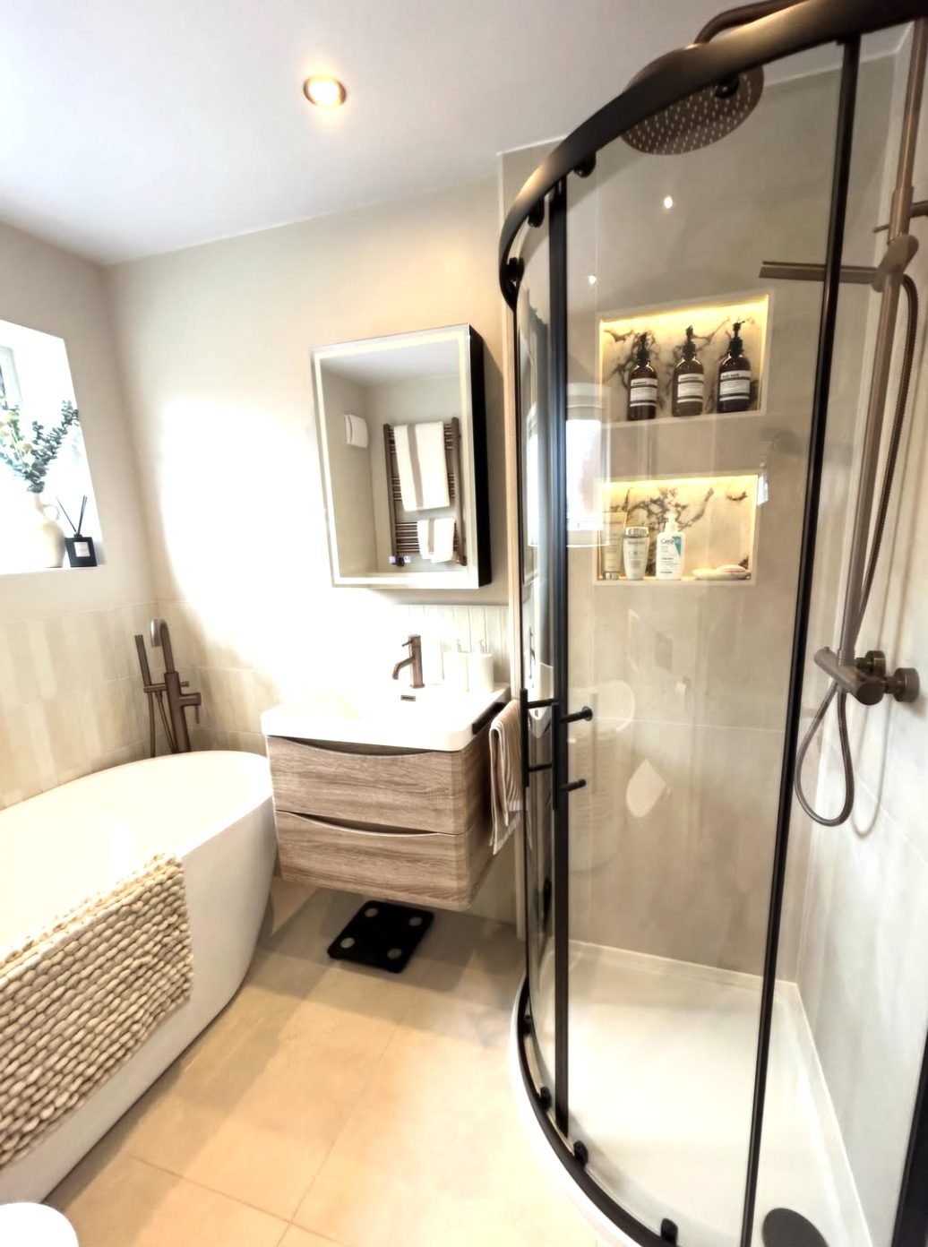 Warm neutral bathroom with freestanding bath and curved quadrant shower enclosure